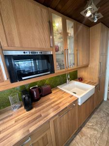 a kitchen with a microwave and a sink at Nannerls Penthouse in Sankt Gilgen