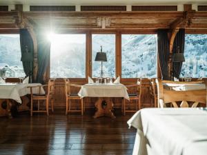 restauracja ze stołami i krzesłami z górami w tle w obiekcie Relais & Chateaux Schönegg w mieście Zermatt