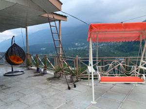 The Vashisht, Manali - A Four Star Luxury Hotel في مانالي: غرفه فيها سلم وكرسي فوق جبل