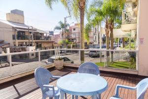 a table and chairs on a balcony with a view of a street at HANNA San Diego Apart Hotel in Florianópolis