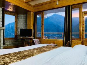 The Vashisht, Manali - A Four Star Luxury Hotel في مانالي: غرفة نوم بسرير وإطلالة على جبل