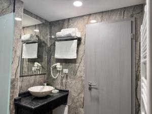 bagno con lavandino bianco e specchio di Hanul Domnesc Imperial Hotel & SPA a Călan