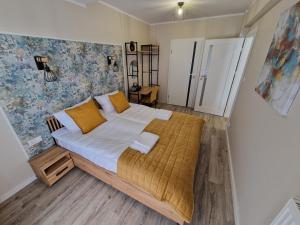 ein Schlafzimmer mit einem großen Bett mit gelben Kissen in der Unterkunft Busko-Vita in Busko-Zdrój