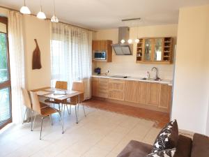 una cucina e una sala da pranzo con tavolo e sedie di PRESTIGE PARK apartament z tarasem i parkingiem a Krynica-Zdrój