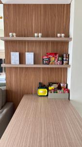 a room with a table and shelves with food at Apt Puri Orchard at puri in Jakarta