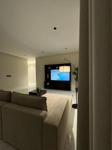 sala de estar con sofá y TV de pantalla plana en Sunrise Luxury Two Bedroom Apartment, en Al Khobar