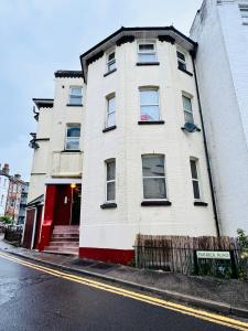 um edifício branco com uma porta vermelha numa rua em Purbeck Inn Entire Apartment in Bournemouth town centre em Bournemouth