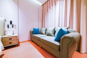 a living room with a couch with blue pillows at Zhangjiajie Han Exotic Inn in Zhangjiajie