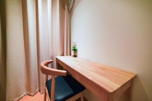 a wooden desk with a chair next to a curtain at Zhangjiajie Han Exotic Inn in Zhangjiajie