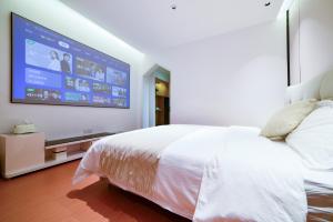 a bedroom with a large bed and a flat screen tv at Zhangjiajie Han Exotic Inn in Zhangjiajie