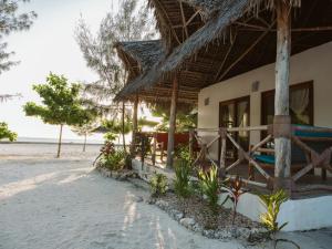 una casa sulla spiaggia con tetto di paglia di Bahati Sunset Bungalows Michamvi a Michamvi Kae