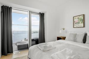 オーフスにあるEndless ocean views with private balconyのベッドルーム1室(ベッド1台、大きな窓付)