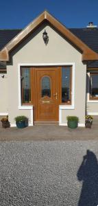 une maison avec une porte en bois et deux plantes dans l'établissement Beachmount house, à Cork