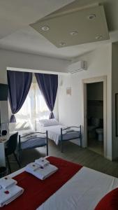 a hotel room with two beds and a window at U Baruni B&B in Messina