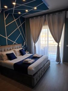 a bedroom with a large bed with a large window at U Baruni B&B in Messina