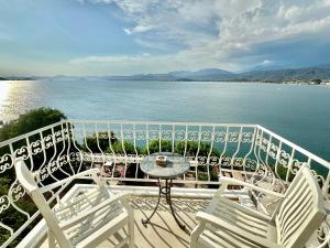 uma varanda com cadeiras, uma mesa e água em Ece Hotel Sovalye Island em Fethiye