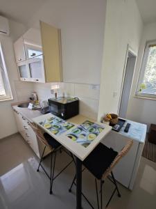 cocina con mesa con sillas y fregadero en Apartments Three Ohrid, en Ohrid