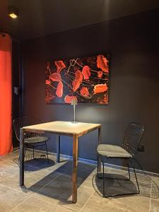 a table with two chairs and a painting on the wall at Le 7 in Vieille-Toulouse