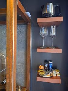 a bathroom with shelves with wine glasses and a sink at Le 7 in Vieille-Toulouse