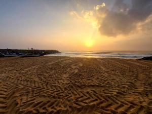 piaszczysta plaża z zachodem słońca nad oceanem w obiekcie DIVINE BEACH INN - The sea shore hotel w mieście Puducherry