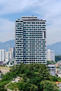 un alto edificio con alberi di fronte ad una città di More than Sokcho a Sokcho