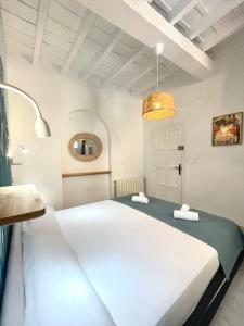 una camera da letto con un grande letto bianco con due asciugamani di House -Rooftop&Jacuzzi -StayInSeville a Siviglia