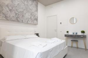 um quarto branco com uma cama branca e uma mesa em Relais Palazzo Nizza - Luxotel & Apartotel em Salerno