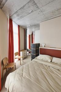 - une chambre avec un grand lit et des rideaux rouges dans l'établissement Ariv Design Apartments Zug, à Cham