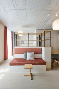 - une chambre avec un grand lit et un banc en bois dans l'établissement Ariv Design Apartments Zug, à Cham