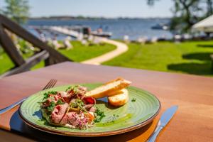 une assiette de nourriture avec de la viande et du pain sur une table dans l'établissement Stare Sady Chillout Rooms "Pod Jabłoniami", à Mikołajki