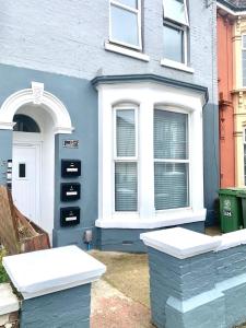 una casa blu con porta bianca e finestre di Luxury 2 Bedroom Apartment Southsea - Free Parking a Portsmouth