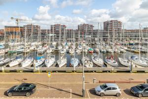 Bizstay Harbour II Scheveningen Apartments في شيفيننغن: مجموعة سيارات متوقفة في مرسى مع قوارب