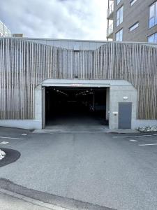 un grand bâtiment avec un tunnel dans un parking dans l'établissement Leilighet Smeasundet, à Haugesund