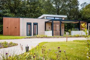 a house with a pivot door on a driveway at Recreatiewoning 'Steenpatrijs' in Voorthuizen