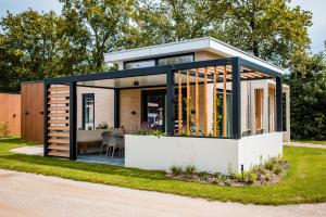 a small house with a black roof at Recreatiewoning 'Steenpatrijs' in Voorthuizen