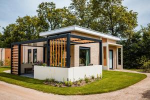 a small house with a lot of windows at Recreatiewoning 'Steenpatrijs' in Voorthuizen