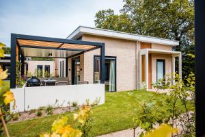 a home with a large glass extension to a house at Recreatiewoning 'Steenpatrijs' in Voorthuizen