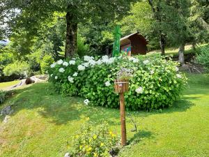 een bloementuin met een vogelvoeder in het gras bij Počitniška hiša ErOs in Bohinj