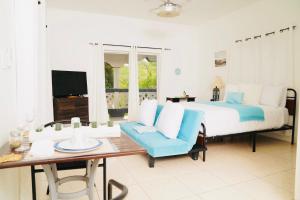 1 dormitorio con cama, mesa y TV en Villa Serenity- Water View Suite, en Providenciales