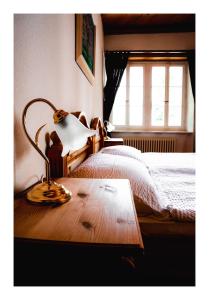 ein Schlafzimmer mit einem Bett und einer Lampe auf einem Holztisch in der Unterkunft B&B Château la Grande Riedera 