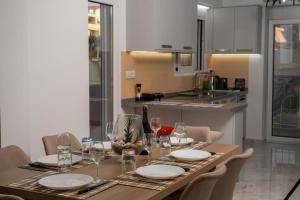 una mesa de comedor con platos y copas de vino en EDEL Luxury Apartments, en La Canea