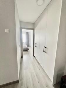 Naujoji AkmenėNaujoji Akmenė Apartment Ramučiai的一间空房间,走廊上设有白色橱柜