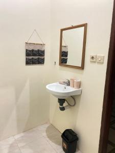 bagno con lavandino e specchio a parete di Family Garden Homestay a Senggigi