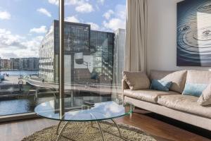 ein Wohnzimmer mit einem Sofa und einem Glastisch in der Unterkunft Copenhagen Island Hotel in Kopenhagen