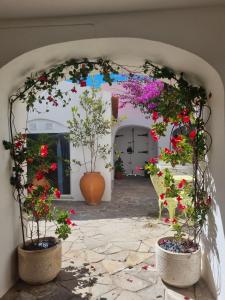 ein Torbogen mit Blumen in Töpfen auf einem Innenhof in der Unterkunft Castle House and Beach in Sines