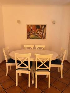 uma mesa de jantar com cadeiras e um quadro na parede em Quinta do Marmeleiro em Santiago do Cacém