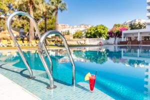 un drink con ombrellone accanto alla piscina di THB San Fermín a Benalmádena