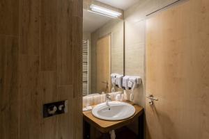 bagno con lavandino e specchio di GENESIS by Eden a Predeal