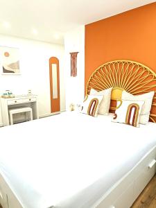 - une chambre avec un grand lit et un mur orange dans l'établissement SUPERTUBOS HOUSE Peniche, à Peniche