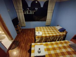 a small room with two beds and a window at Inti Ut'ha in Puno